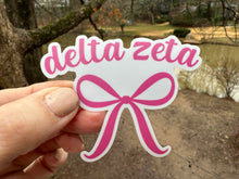Load image into Gallery viewer, Sticker | DZ | Delta Zeta Pink Bow | Waterproof Vinyl Sticker | White | Clear | Permanent | Removable | Window Cling | Glitter | Holographic