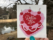 Load image into Gallery viewer, Sticker | DZ_C | Delta Zeta Heart Shaped Cake | Waterproof Vinyl Sticker | White | Clear | Permanent | Removable | Window Cling | Glitter | Holographic